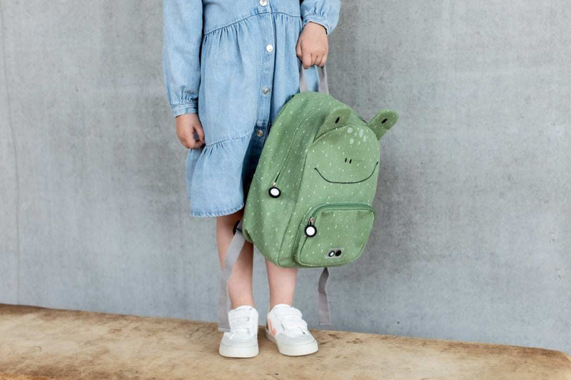 Child holding green Backpack Mr. Frog with adjustable straps and front pocket